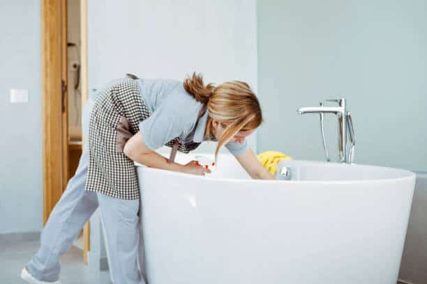 Young Woman doing household chores ,cleaning bathroom tub